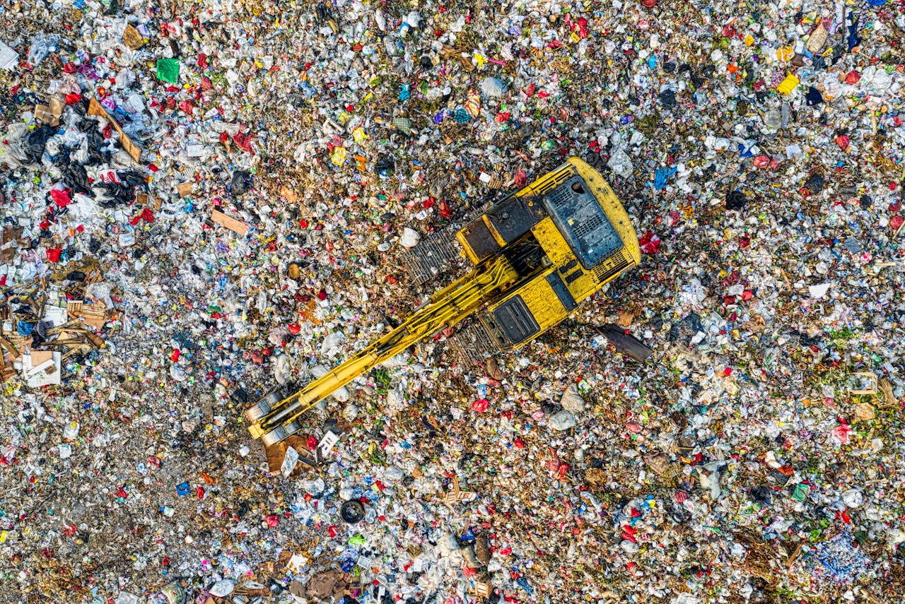 Services-03 Aerial shot of a landfill with a yellow excavator in South Tangerang, Indonesia.